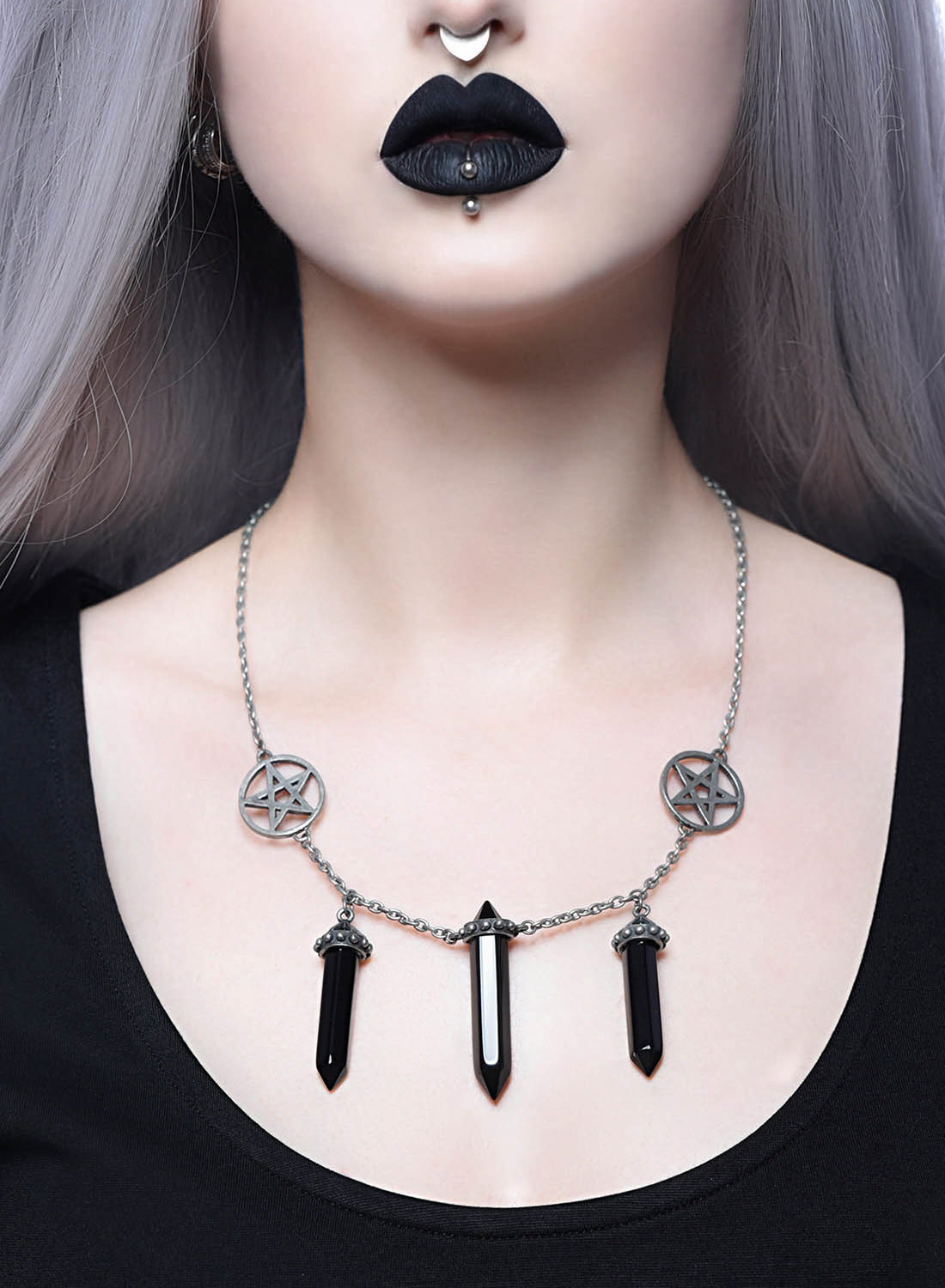 Killtarin Trinity-kaulakoru, jossa on hopeanvärinen ketju, pentagrammi ja mustat riipukset. Valmistettu 100 % metalliseoksesta. Koko: 60 cm.